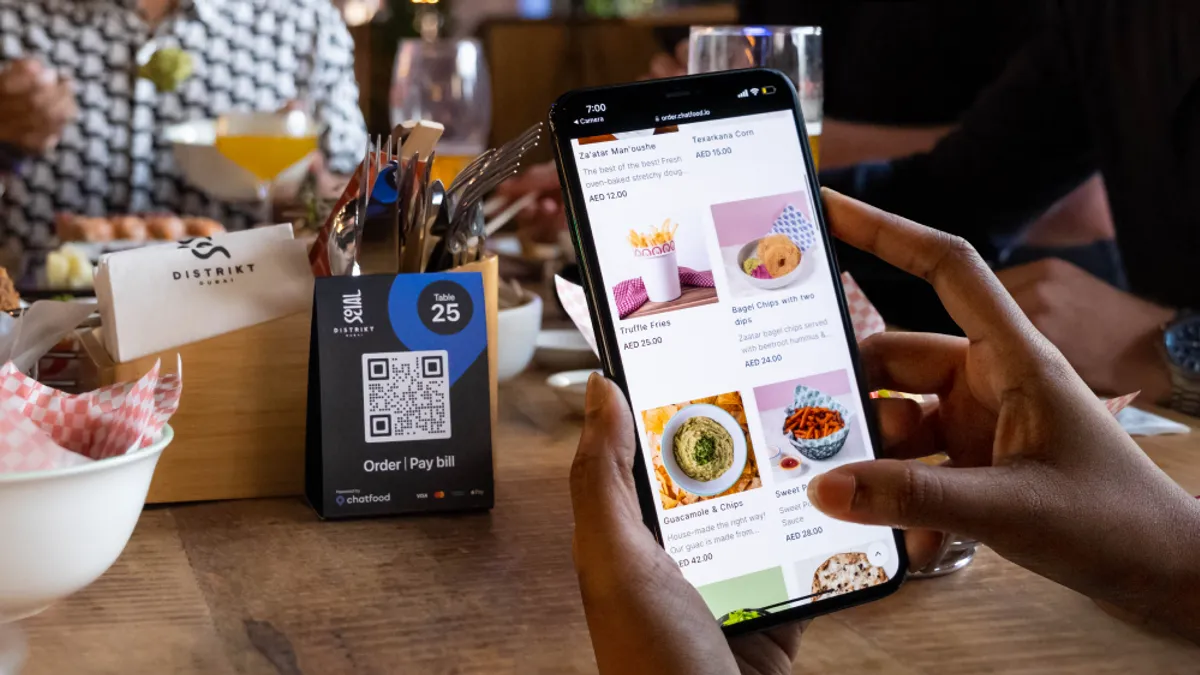 A picture of someone scanning a QR code at a restaurant.