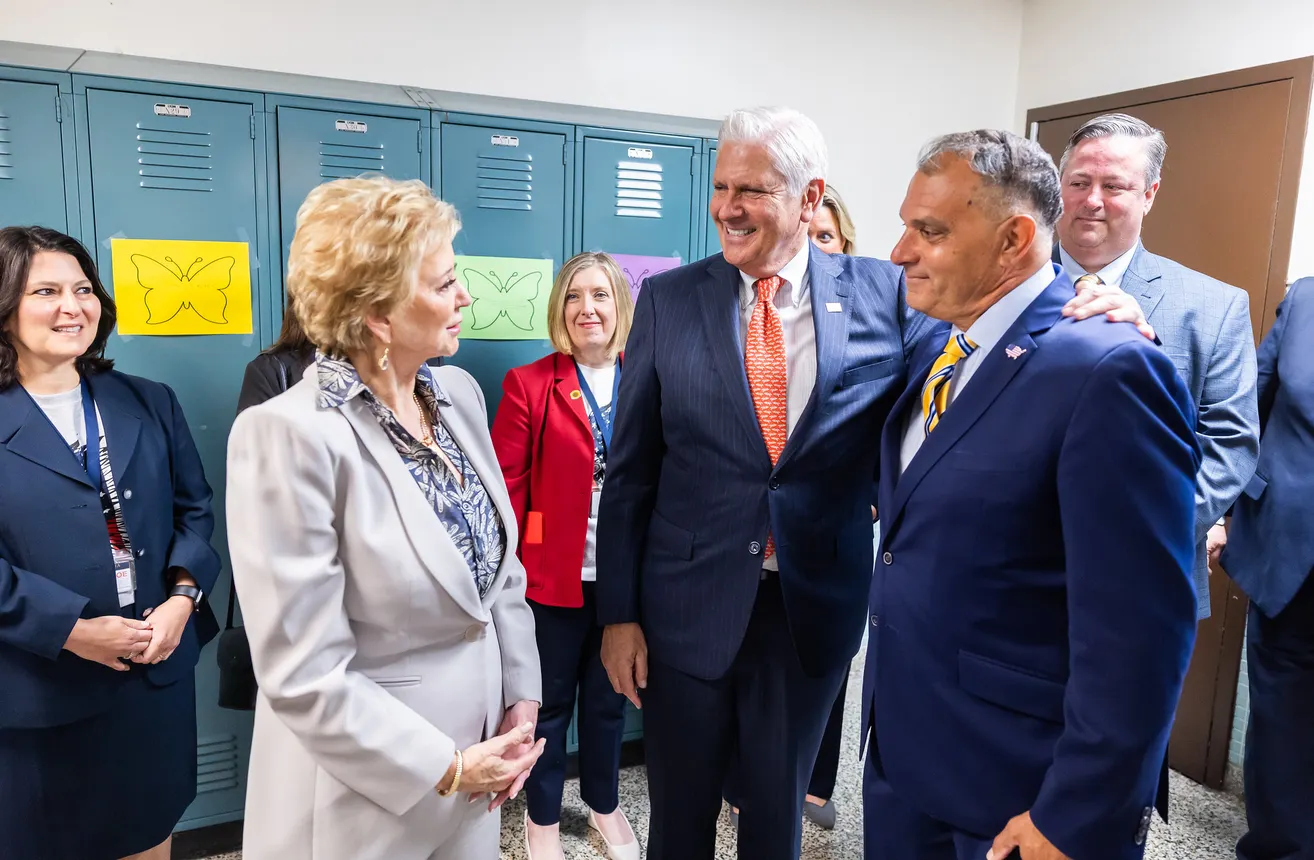 Secretary Linda McMahon stands with two school district leaders