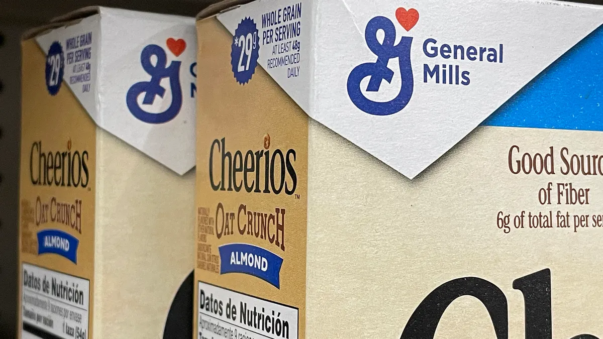 Boxes of General Mills cereal are displayed on a grocery store shelf.