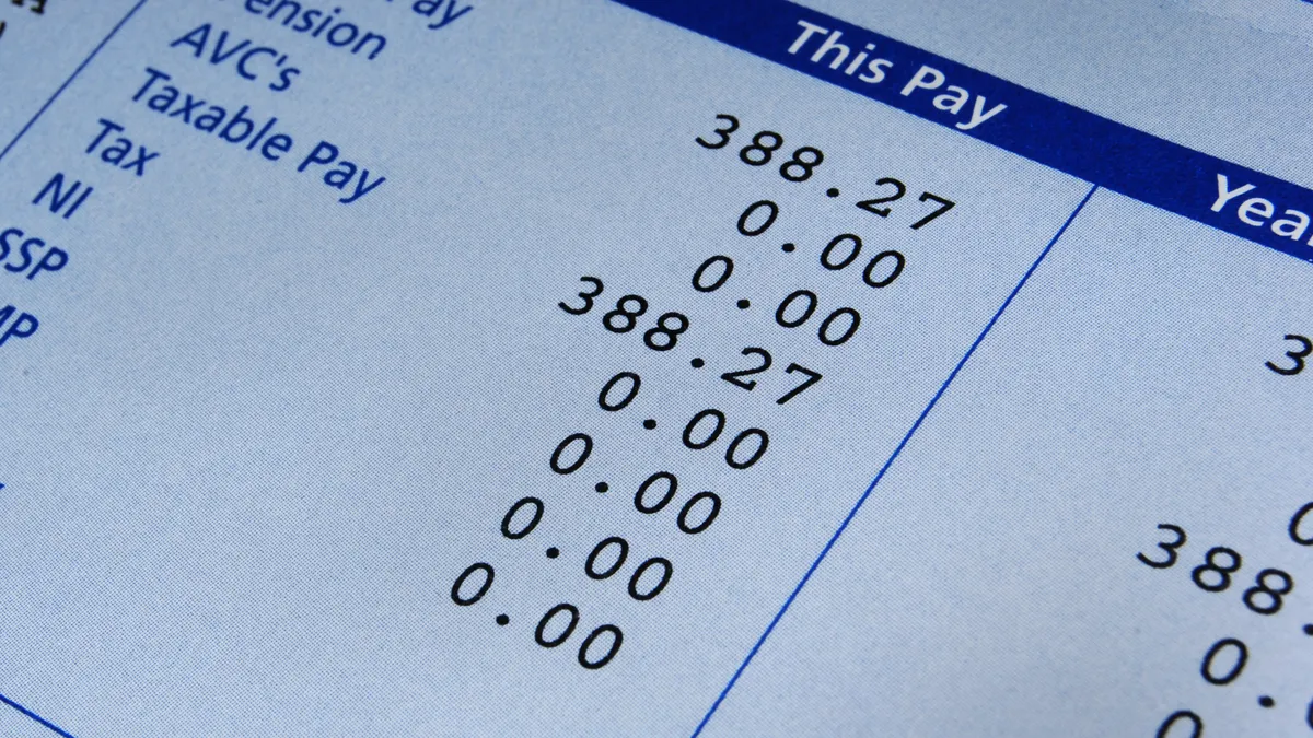 A pay slip or stub with calculations, including tax information, is pictured.