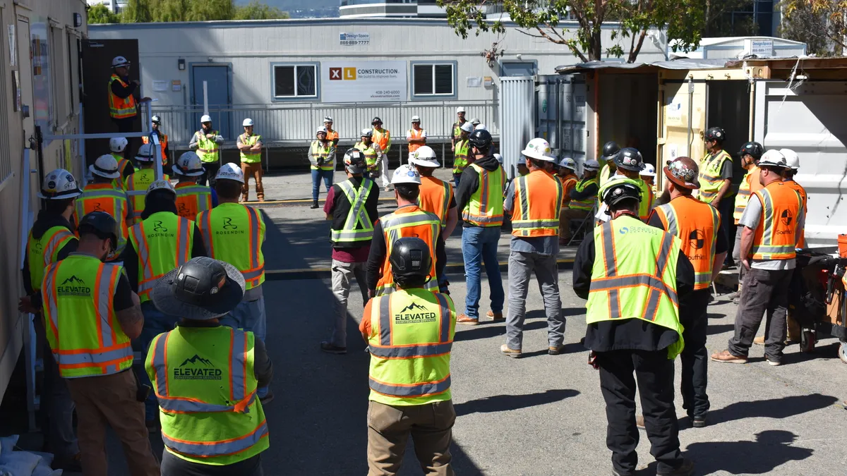 Construction workers listen to a mental health huddle discussion on an XL Construction jobsite.