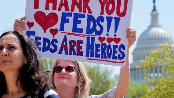 A woman holds up a sign in front of the U.S. Capitol