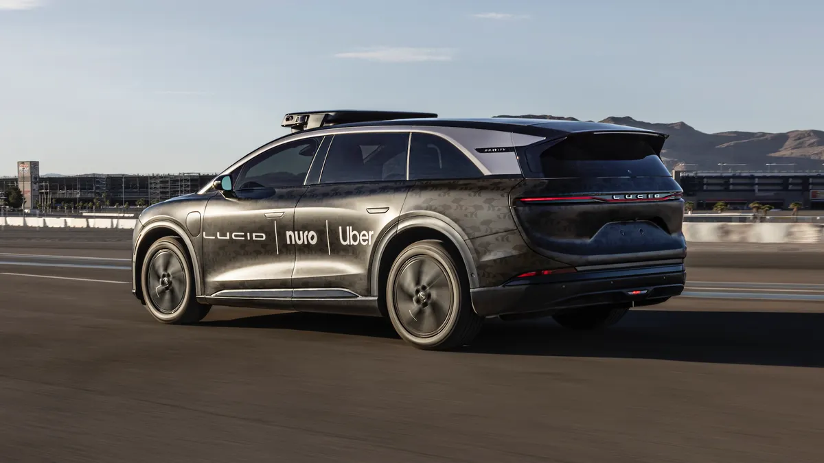 Lucid Gravity robotaxi equipped with roff-mounted sensors and the logos of Uber, Nuro and Lucid on the side doors.