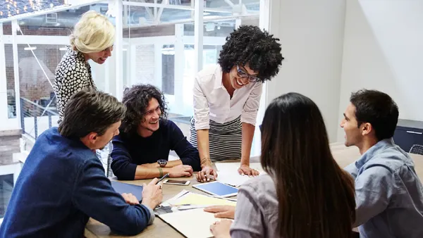 Group of millennials in meeting room working at a table.