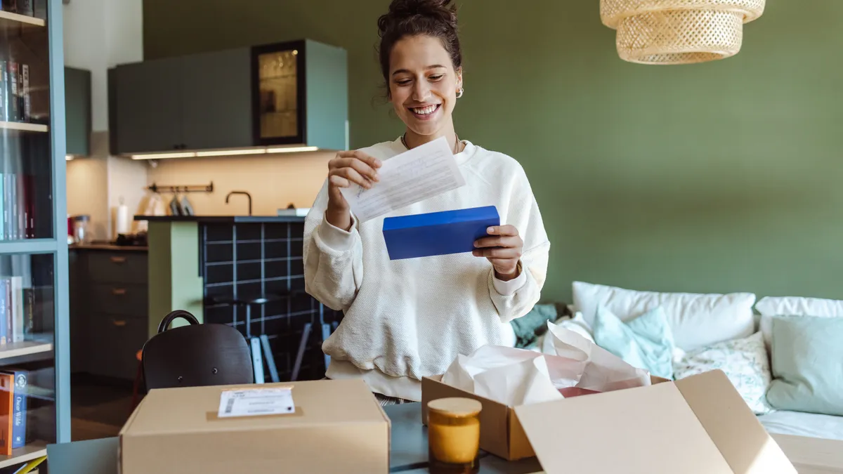 A person opens a package and reads a note.