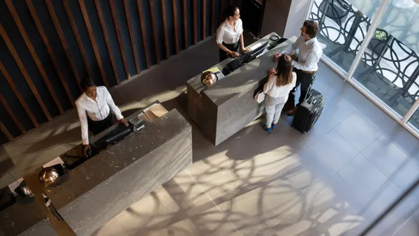 Guests check in with the front desk in a hotel lobby