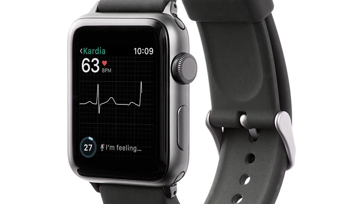 An Apple Watch with a small, metal sensor on the band displays a heart rate.