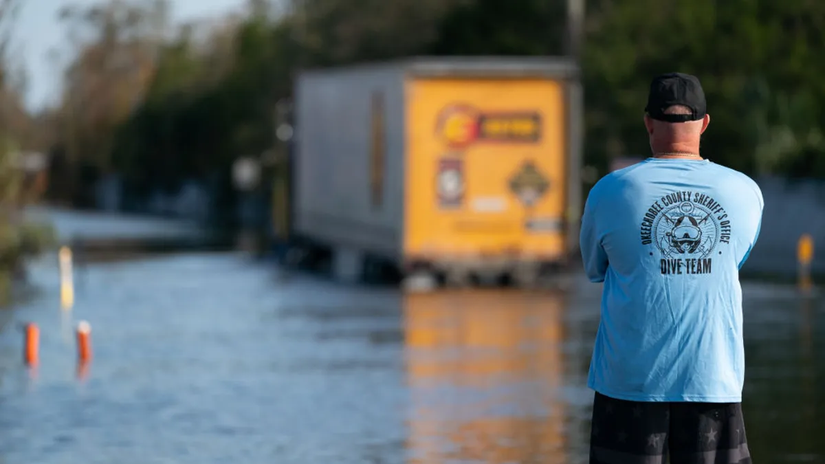 A truck drives through water to reach a community in Florida affected by Hurricane Ian.