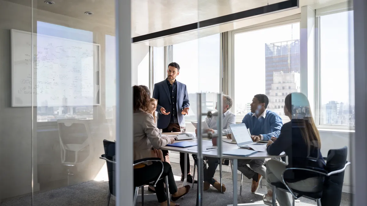 Businessperson talking to a group of people in a meeting a the office