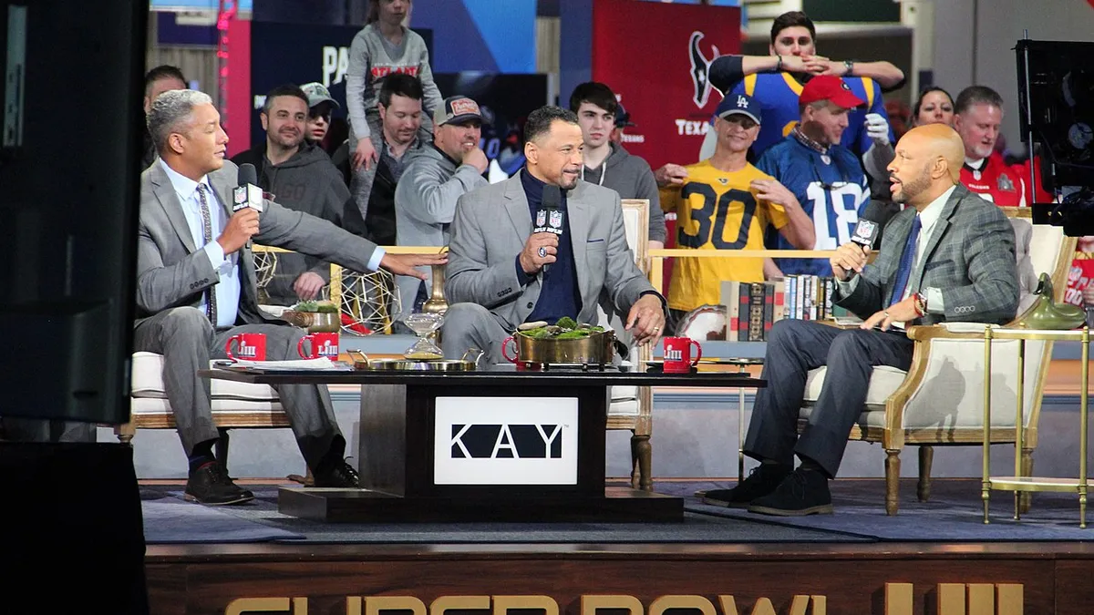 Jim Trotter, Rod Woodson, and Steve Wyche host panel at Super Bowl LIII Experience with football fans in the background