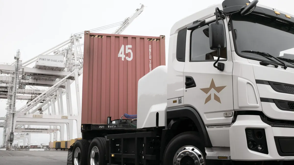 A white freight trucks with a red-tan container.