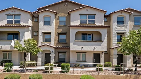 Front view of tan three-story apartment transaction.