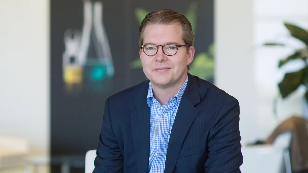 Neumora CEO Henry Gosebruch stands for a photo against a blurred office background