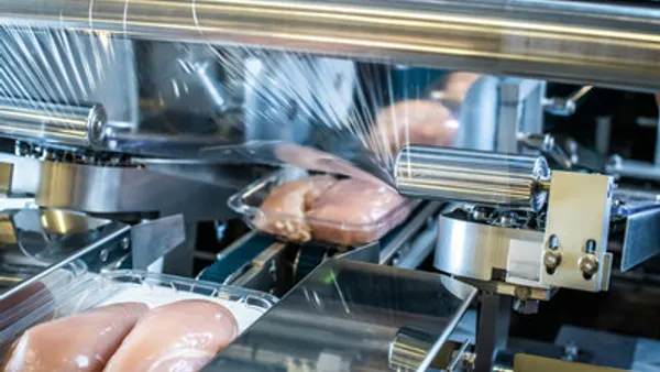 A production line seals poultry packages with plastic film made from chemically recycled content