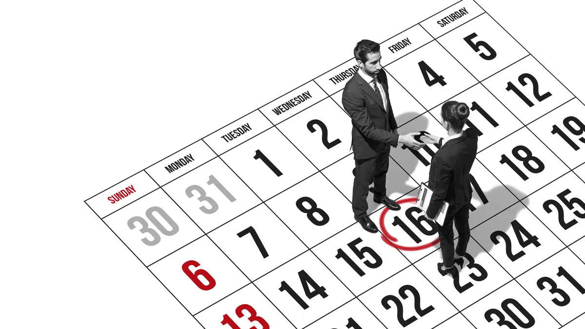 Business people meeting and shaking hands, they are standing on a planner calendar