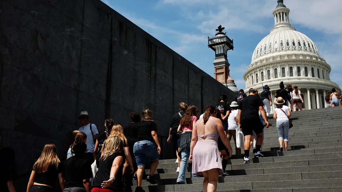 A group of people walk up outside stairs toward the U.S. Capitol building in Washington, D.C.