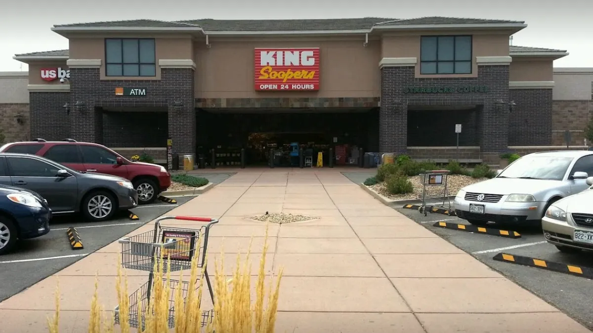 Exterior of building with a King Soopers sign and cars parked on either side