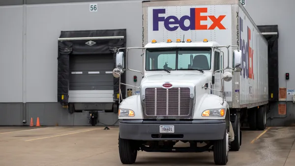 A FedEx Freight truck is stationed at a dock door.