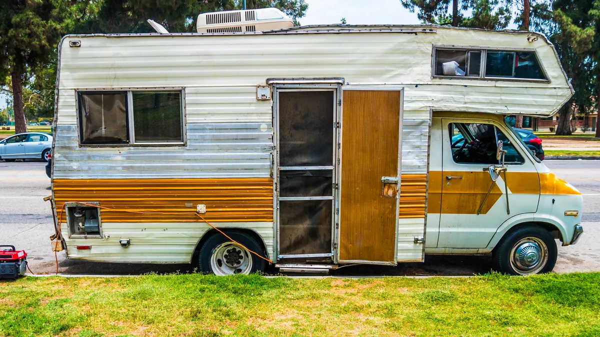 A vehicle parked on the curb in front of grass.