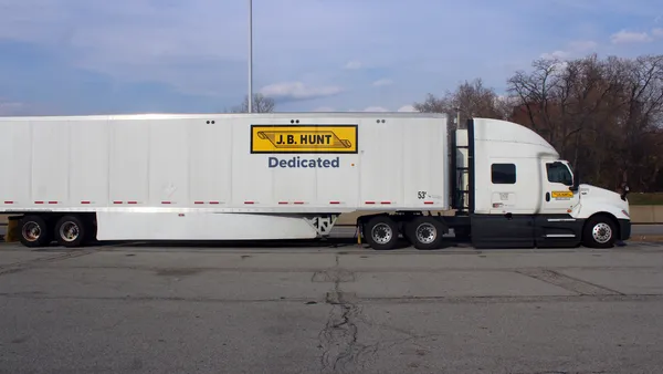 A J.B. Hunt tractor-trailer at a Pennsylvania Turnpike rest stop during an October afternoon with a roadway light behind it.