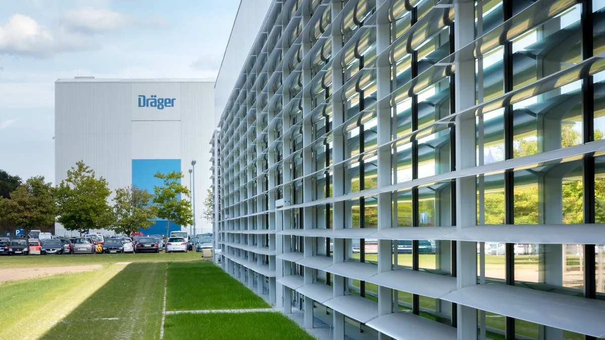 A building with a windowed wall and a sign that reads "Dräger"