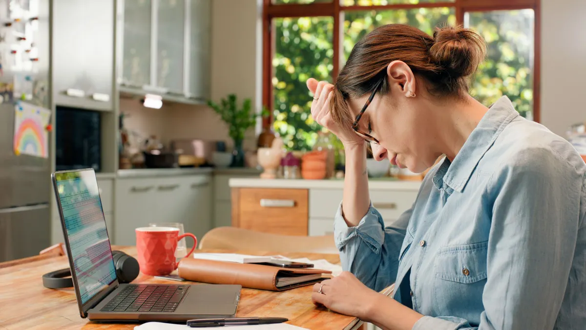 Frustrated woman working at home looking over paperwork