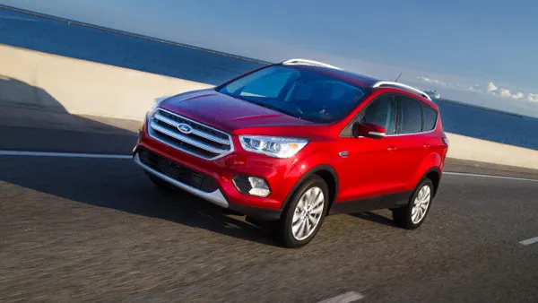 A red 2017 Ford Escape Titanium SUV on a road near a beach.