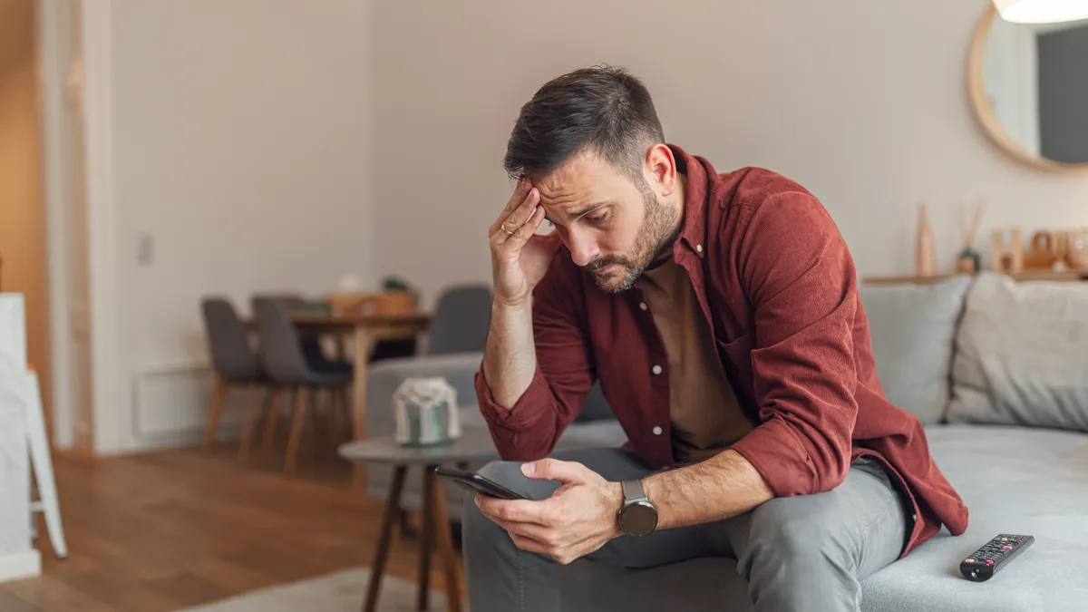 A man is stressed as he looks at his phone