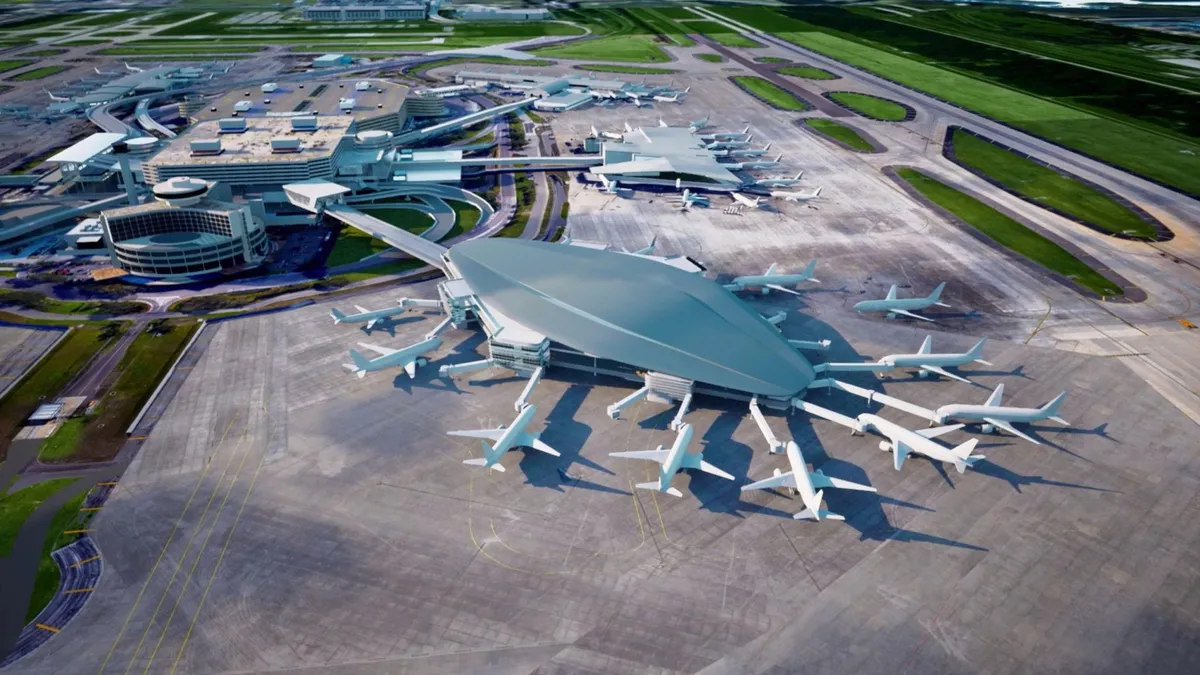 A roughly oval shaped building with a silver roof extends from the main terminal, with about a dozen airplanes parked around it.