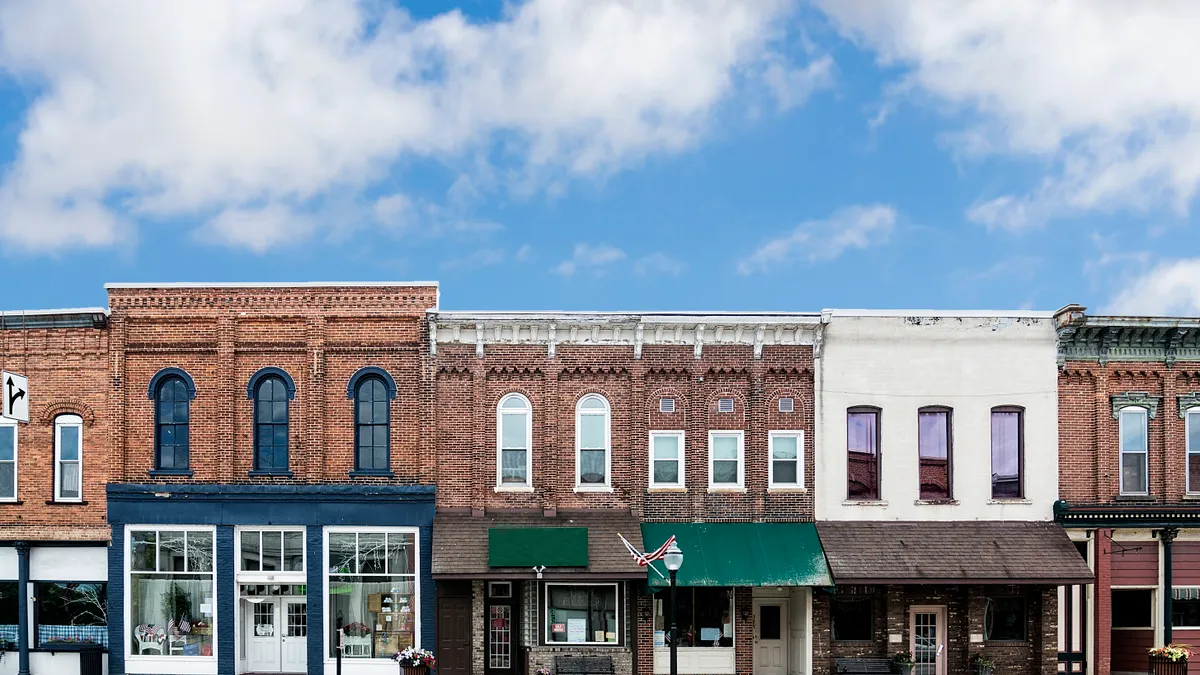 A row big buildings with small shop storefronts underneath.