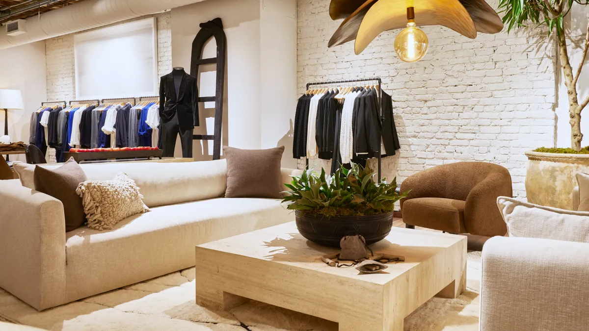 An interior of the Banana Republic flagship store. Two couches and a coffee table with clothes on racks in the background.