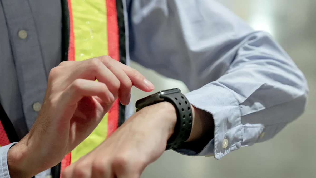 Confident businessman looking on the smart watch. The concept of engineering