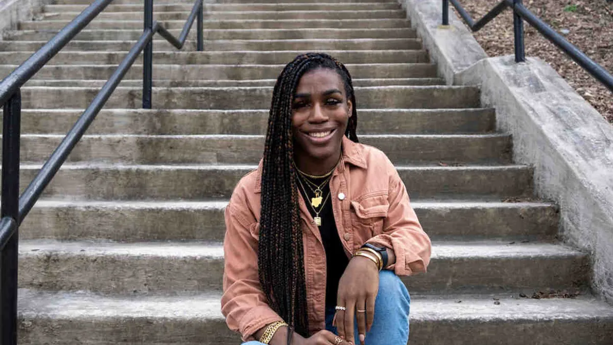 Transgender student Andraya Yearwood sits on outdoor steps and smiles