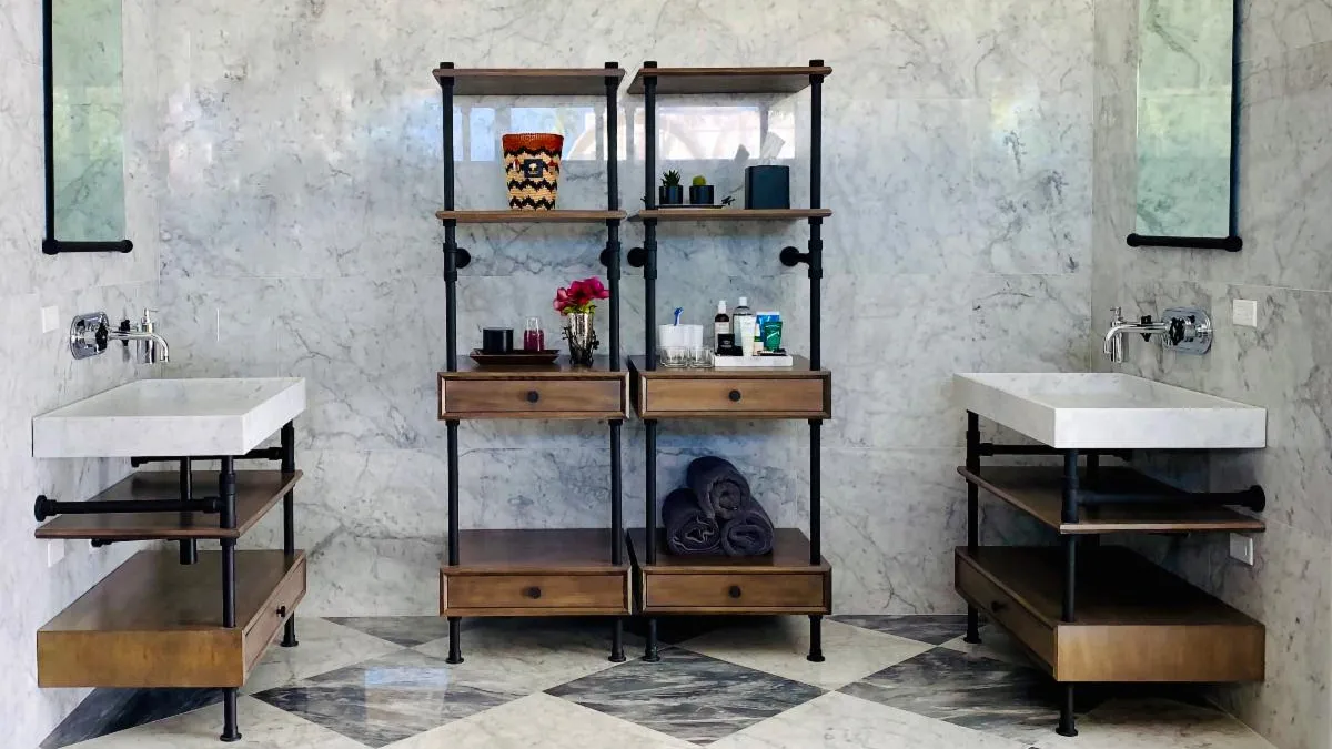 A bathroom with two sinks and wood storage shelves.