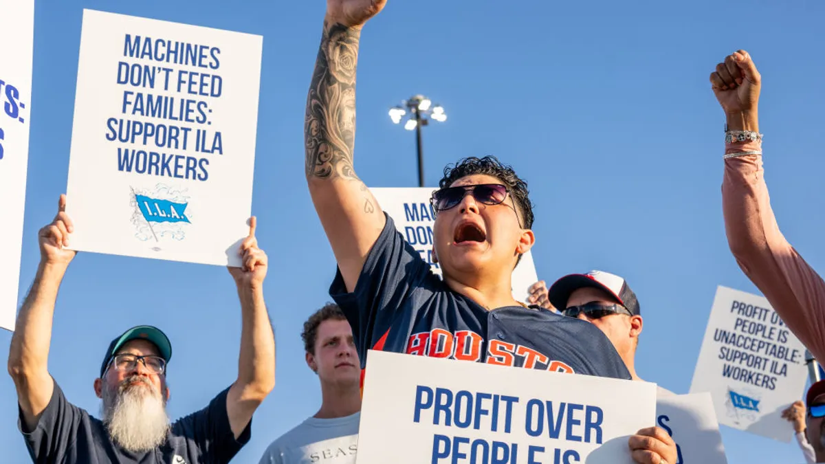 A group of people holding picket signs are seen