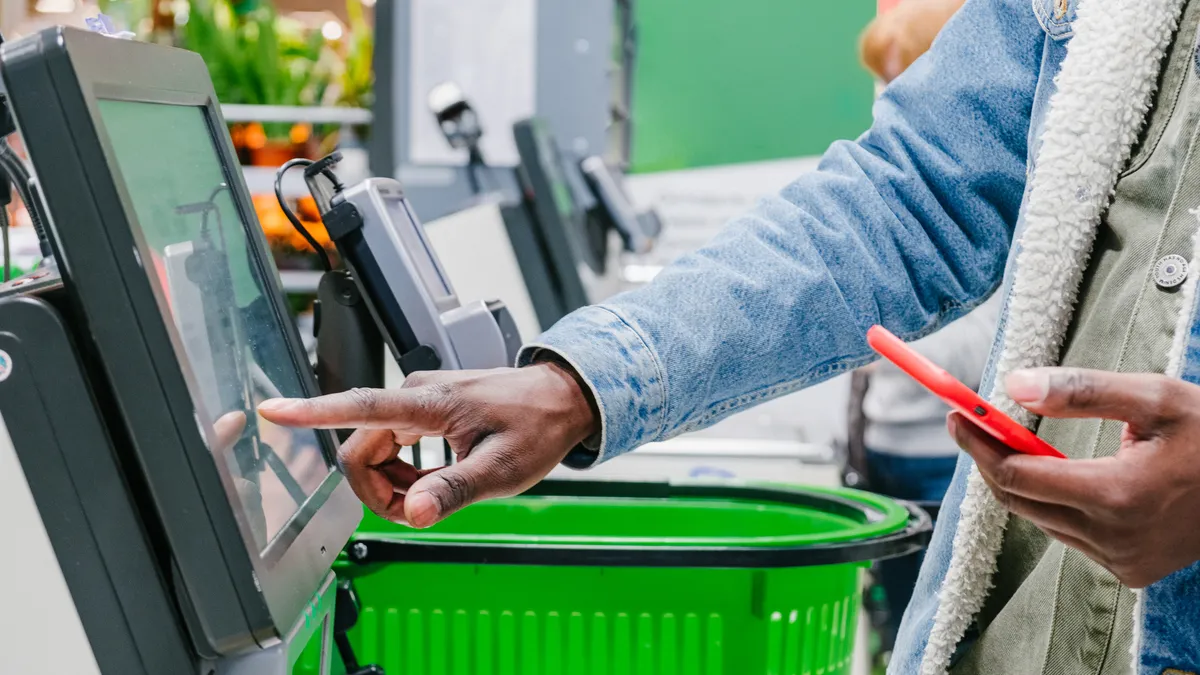 Person using a self-checkout station at a supermarket