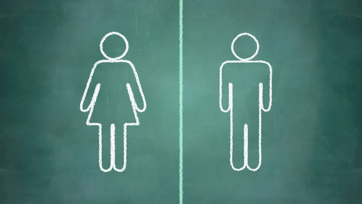 A drawing on a chalkboard depicting the female and male signs for public bathrooms.