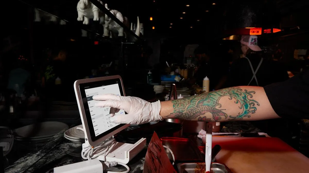A worker uses a Square tablet.