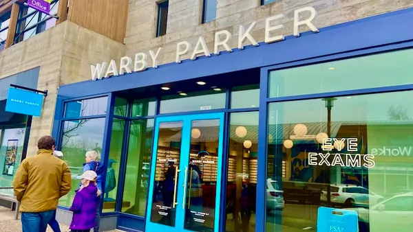 People walking past a Warby Parker store.