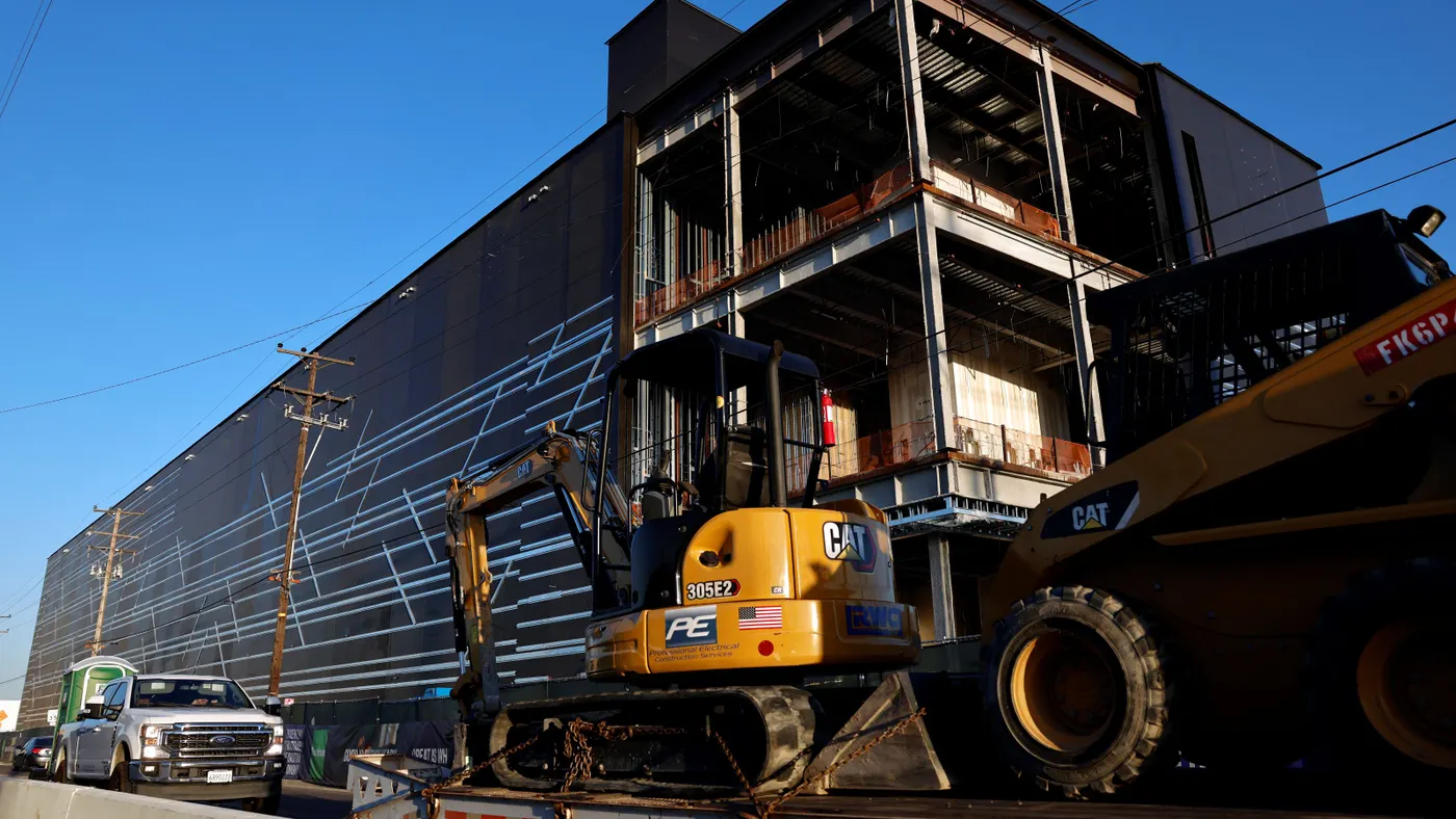 Construction equipment sits near a large building.