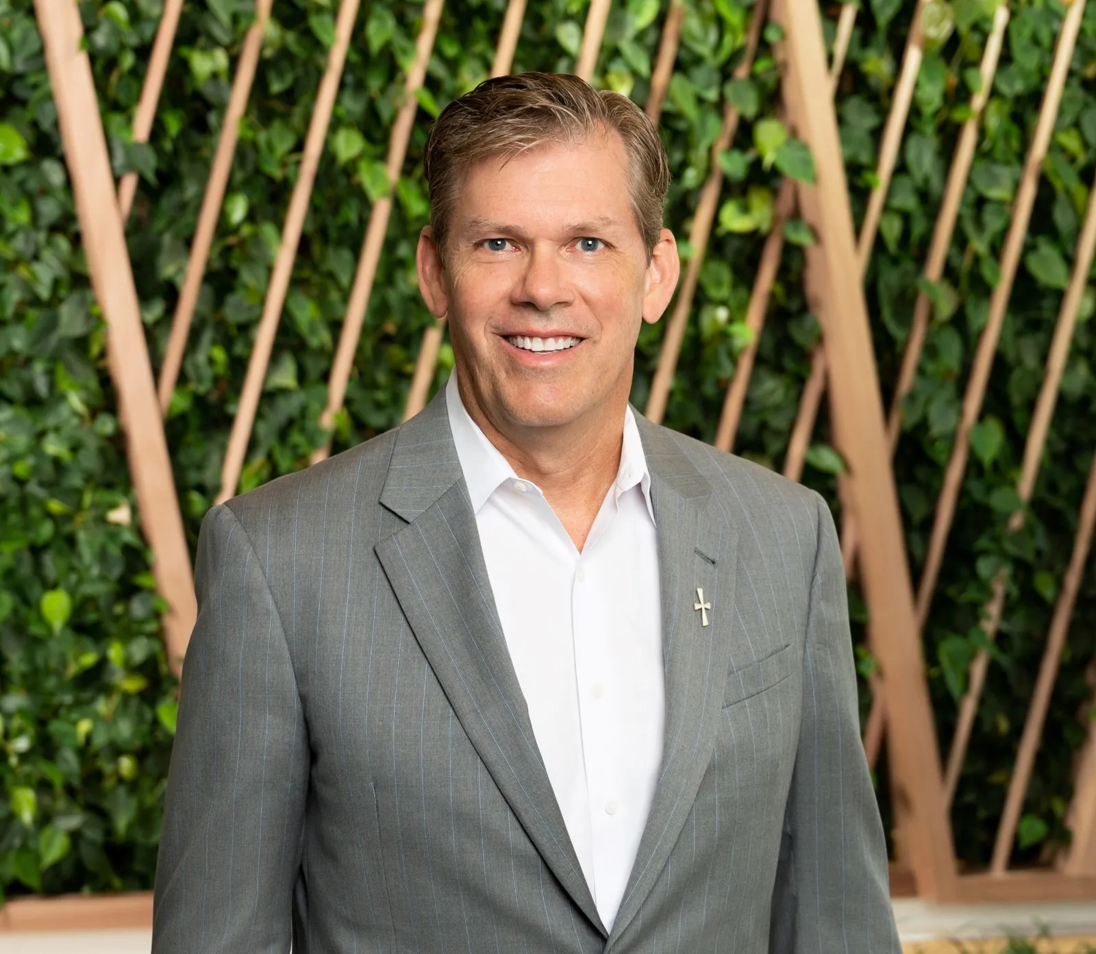 Man standing in suit in front of green background