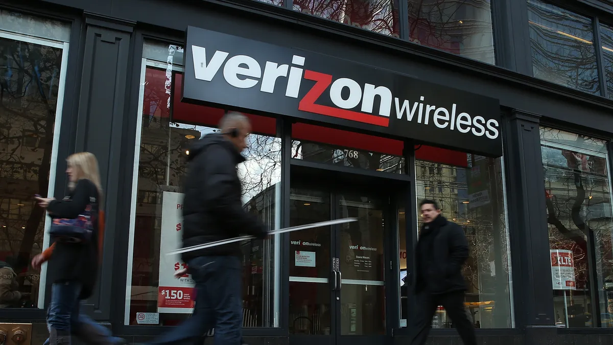 Pedestrians walk by a Verizon Wireless store.