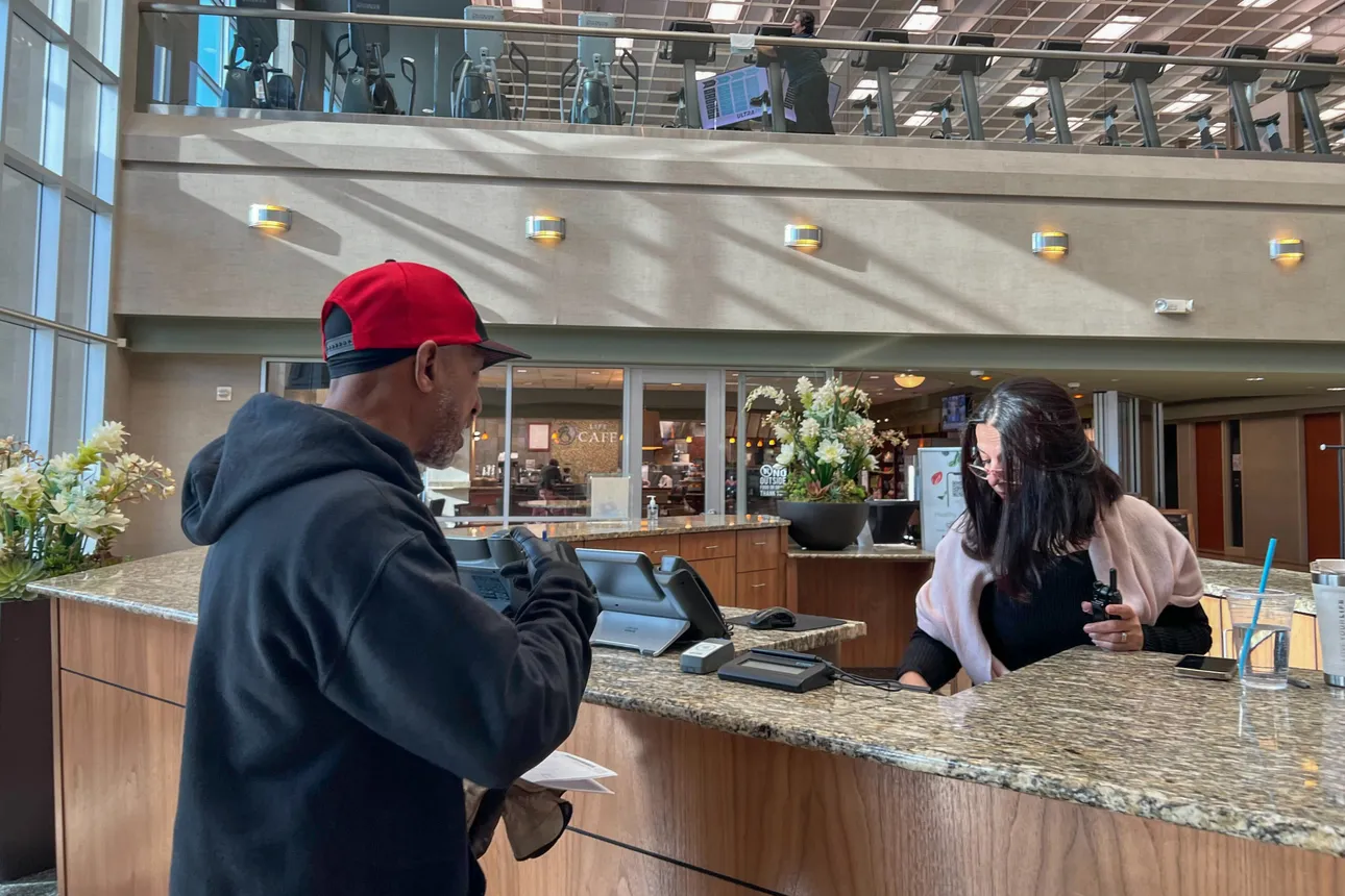 XPO driver Steadman Mitchell asks the front desk attendant at Life Time where he should drop off a delivery.