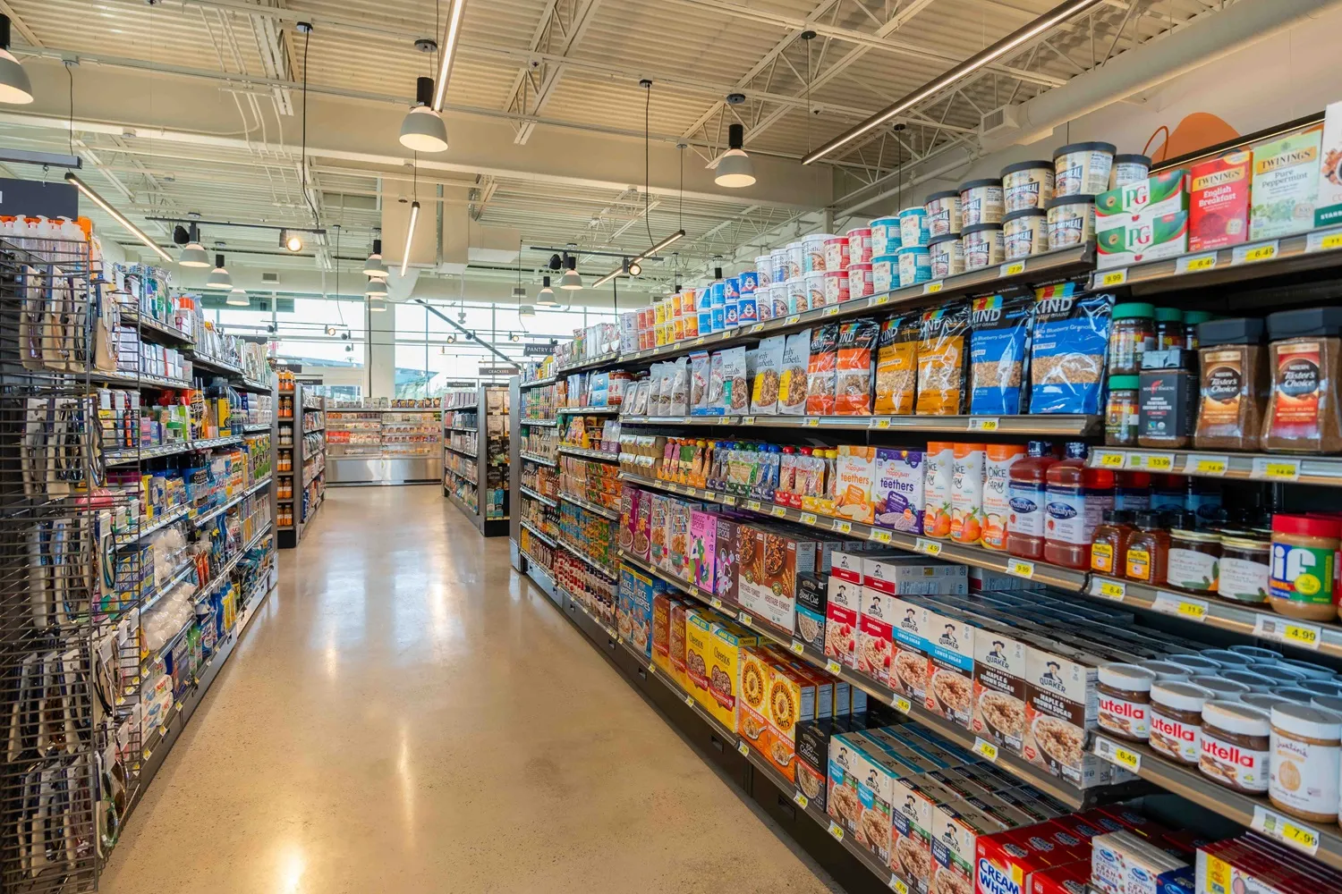 A photo looking down the aisle of a convenience store, showing shelved goods on both sides.