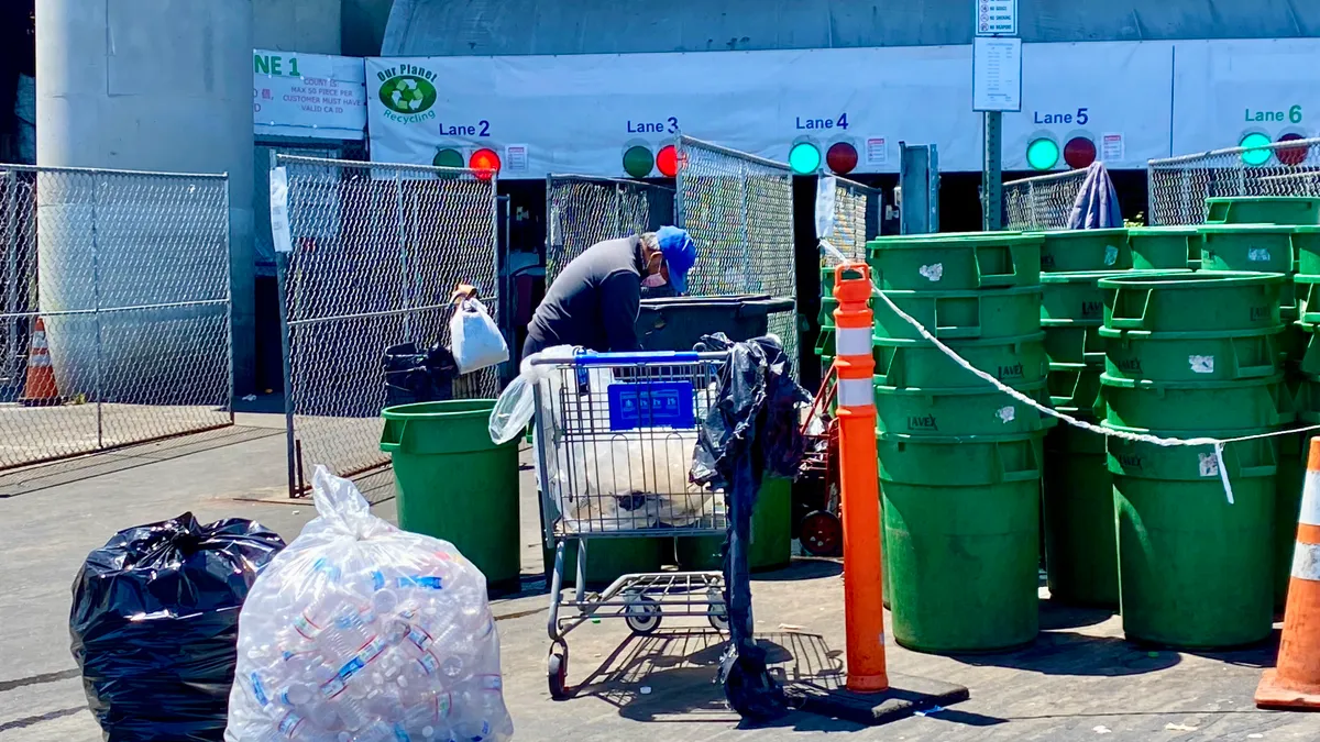 A person drops off beverage containers at a recycling center.