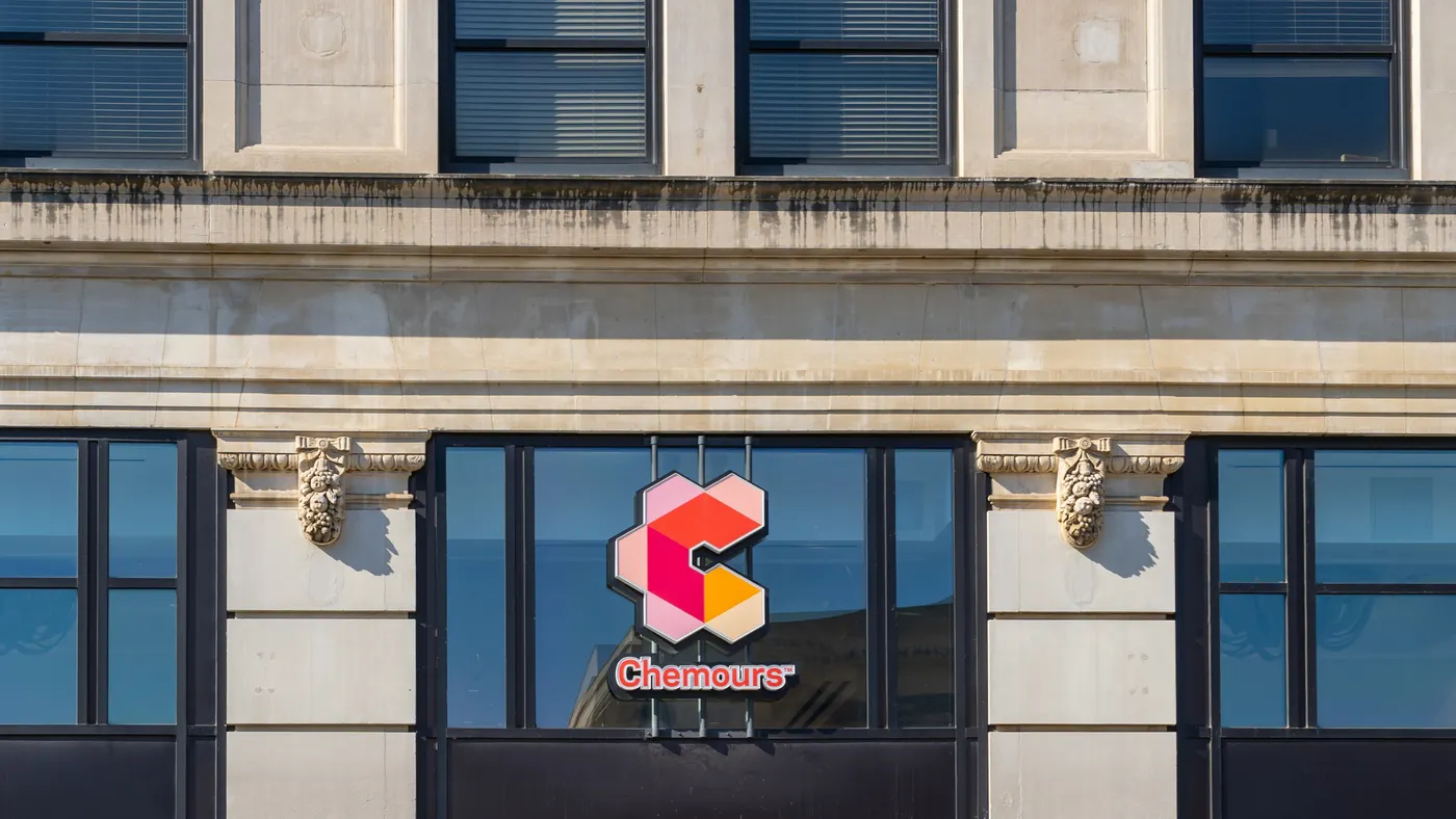 A beige building with dark windows, and the red and orange Chemours logo sign in the center.