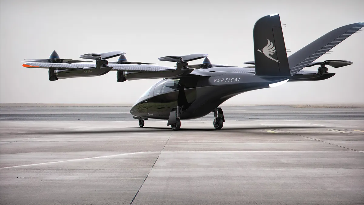 An illustration showing a black electric vertical takeoff or landing aircraft lettered "Vertical" on a runway, in a left rear three-quarter view.