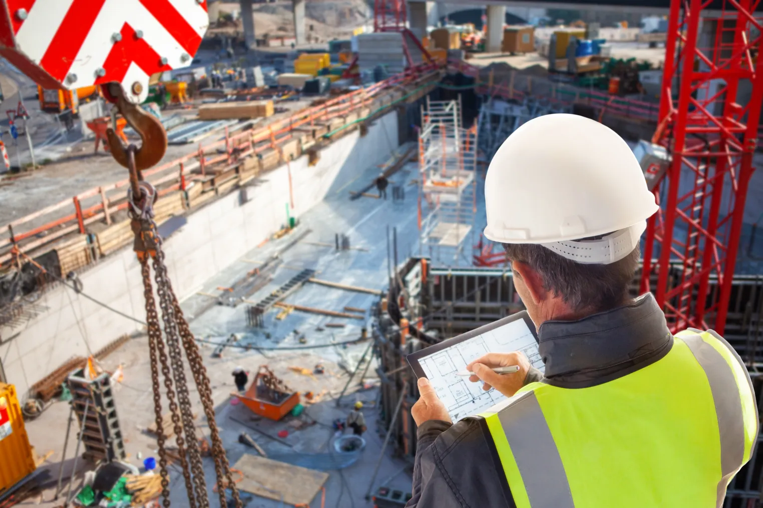 An engineer looks at a table while overseeing a construction site.