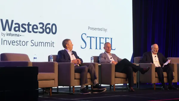 Three people sit on a stage. Behind them, a screen reads "Waste360 by Informa, Investor Summit. Presented by: Stifel."