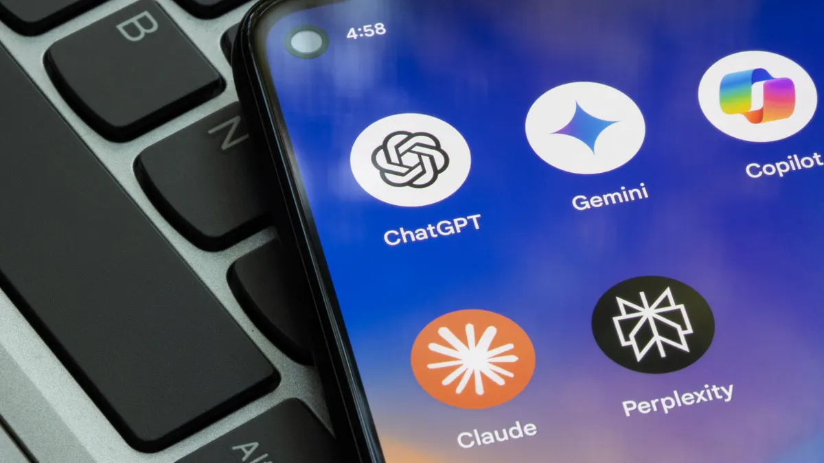 AI apps ChatGPT, Gemini, Copilot, Claude and Perplexity on a smartphone hovering over a computer keyboard .